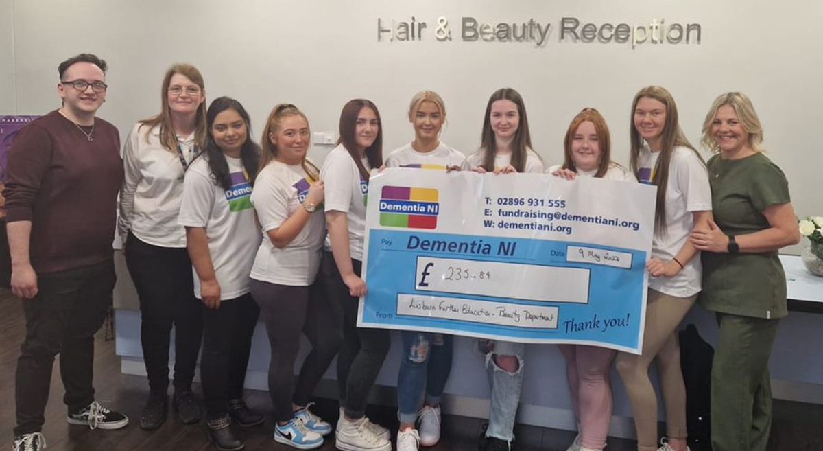 Level 3 Beauty Therapy Students and their tutor present a cheque to Dementia NI representative